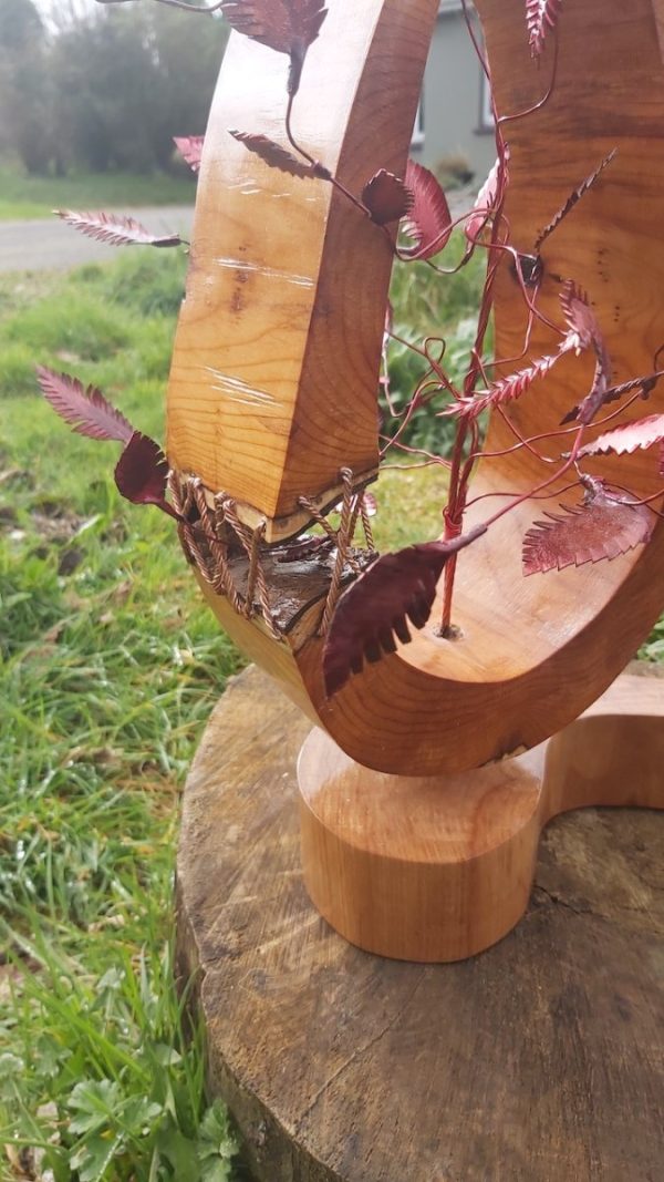 Close up of detail on wood and copper horsedhoe scuplture